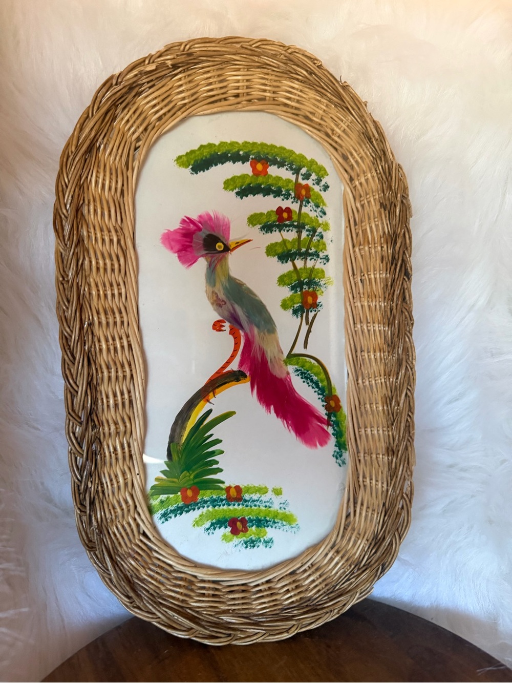 Vintage wicker-framed decorative art with a painted bird motif.